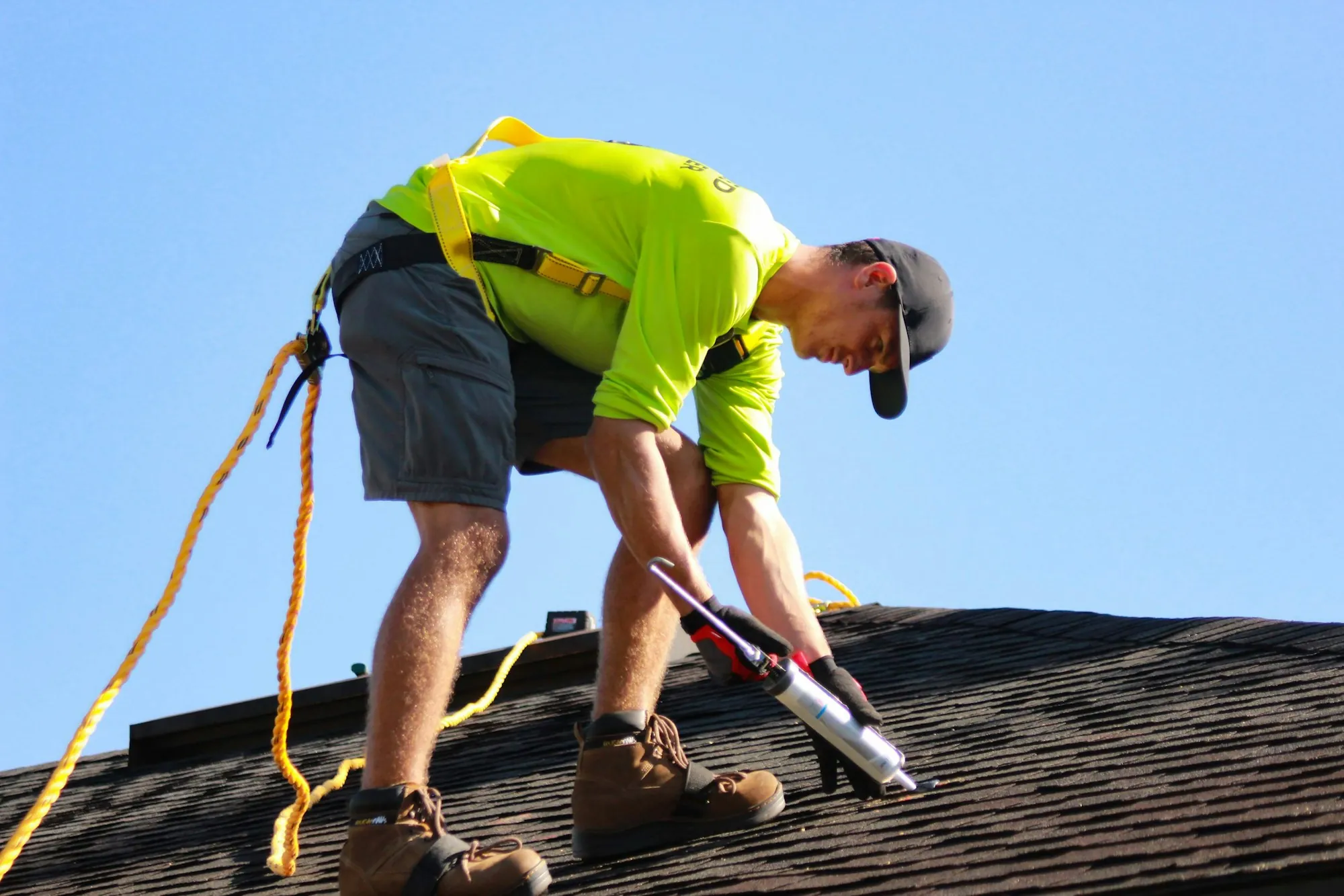 Roofer sealing a detail on a residential asphalt shingle roof