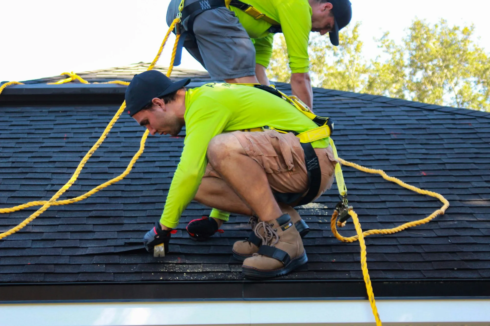 Roofing crew working on a residential asphalt shingle roof